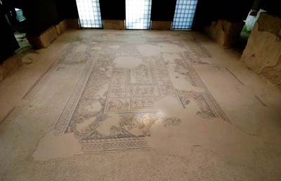 The Triclinium found at Sepphoris. A stone floor painted with an ornate design that has worn down.